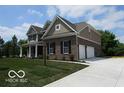 View of a two-story brick home with an attached two car garage and concrete driveway at 7522 Timberfield Ln, Indianapolis, IN 46259