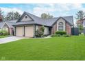 Charming single-Gathering home with a well-manicured front yard and attached two-car garage at 7856 Trotwood Cir, Indianapolis, IN 46256