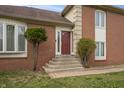 Inviting front entrance featuring a red door, brick facade, and well-maintained landscaping at 8031 Edgewood Ct, Plainfield, IN 46168