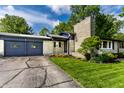 Well-maintained single-story home featuring a stone chimney and a charming entrance with flower beds at 845 W 77Th St S Dr, Indianapolis, IN 46260