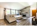 Inviting living room with stone fireplace, a comfortable sectional sofa, and large windows at 845 W 77Th St S Dr, Indianapolis, IN 46260
