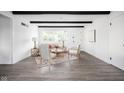 Bright living room features dark wood beams, accent chairs, and views of backyard at 846 W 56Th St, Indianapolis, IN 46228