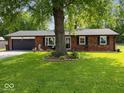 Attractive brick home with a well-kept lawn and a mature shade tree in the front yard at 961 N Dellasburg Rd, Columbus, IN 47203