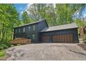 Two-story home with dark wood siding and a two-car garage on a sunny day at 10455 Courageous Dr, Indianapolis, IN 46236