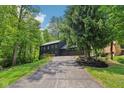 Two-story home with a long driveway surrounded by trees, showcasing its private setting at 10455 Courageous Dr, Indianapolis, IN 46236