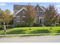 Charming two-story home with a lush green lawn, mature trees, and a well-maintained yard at 10599 Geist View Dr, Fishers, IN 46055