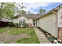 Charming single-story home with a well-manicured lawn, rock garden, and a beautiful blue front door at 10688 Ashview Dr, Fishers, IN 46038