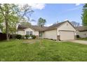 Charming single-story home with a two-car garage, well-maintained lawn, and lovely landscaping at 10688 Ashview Dr, Fishers, IN 46038