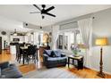 Bright and airy living room with hardwood floors, ceiling fan, an open layout to the kitchen at 10764 Gettysburg Pl, Carmel, IN 46032