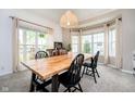 Sunlit dining room with a wooden table, black chairs, and large windows at 11141 Saybrook Ct, Fishers, IN 46037
