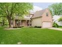 Beautiful two-story home with a well-maintained lawn, covered front porch, and attached two-car garage at 11141 Saybrook Ct, Fishers, IN 46037