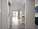 Hallway view of the light-filled apartment with gray wood floors and access to the kitchen and balcony at 1151 Canterbury Ct # D, Indianapolis, IN 46260