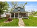 Charming home featuring a welcoming screened-in porch and a beautifully landscaped front yard with a stone walkway at 116 High St, Brooklyn, IN 46111