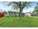 Home exterior with a lush lawn, mature tree, and a charming covered front porch at 126 Brunswick Dr, Greenwood, IN 46143