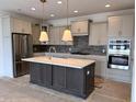 Modern kitchen boasts stainless steel appliances, large island, and stylish lighting at 14913 Higgins Dr, Westfield, IN 46074