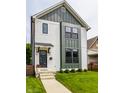 Charming two-story home with white siding, green trim, and well-manicured lawn at 1534 Fletcher Ave, Indianapolis, IN 46203