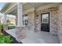 Welcoming front porch with brick accents and a black front door and sidelight at 16112 Lavina Ln, Fishers, IN 46040