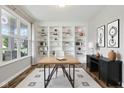 Bright home office featuring custom built-in shelving, hardwood floors, and a large window at 16112 Lavina Ln, Fishers, IN 46040