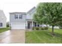 Charming two-story home with an attached garage and well-maintained lawn at 2006 Creek Bank Dr, Columbus, IN 47201