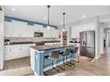 Modern kitchen with white cabinetry, an island with bar seating, stainless steel appliances, and stylish pendant lighting at 2261 Shadow Trace Way, Greenwood, IN 46143
