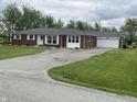 Wide view of the home showing a long driveway leading to the attached garage at 247 N 150 W, Greenfield, IN 46140
