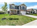 Beautiful two-story home with a well-manicured lawn, a two-car garage, and a lovely tree at 2972 W Patchwork Dr, Monrovia, IN 46157