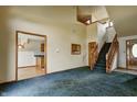 Open-concept living room showcasing the staircase, kitchen entrance, carpet, and ample natural light at 305 Cardinal Dr, Whiteland, IN 46184