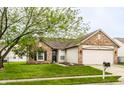 Inviting home with brick and siding exterior, attached garage, and green lawn with mature tree at 4303 Cowslip Ct, Indianapolis, IN 46203
