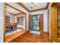 Inviting foyer with rich hardwood floors, decorative wood trim, and an open view into the dining room at 4401 W Hunters Ridge W Ln, Greenwood, IN 46143