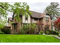 Well-maintained brick home with lush front lawn and beautiful landscaping, offering great curb appeal at 5124 N Capitol Ave, Indianapolis, IN 46208