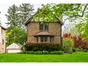 Classic brick home featuring a well-manicured lawn, mature shrubs, and lovely architectural details at 5124 N Capitol Ave, Indianapolis, IN 46208