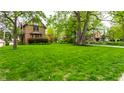 Spacious, lush green front lawn framing a charming brick home with mature trees, perfect for outdoor enjoyment at 5124 N Capitol Ave, Indianapolis, IN 46208