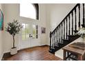 Bright foyer features wood flooring, a staircase with dark wood banister, and a glass front door at 5255 Apache Moon, Carmel, IN 46033