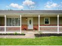 Charming front porch with a white picket fence and an oval-glass front door at 5305 N Cork Dr, Muncie, IN 47304