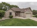 Beautiful brick home with an attached garage, an American flag, and lush green lawn at 5499 Steven Dr, Greenwood, IN 46142