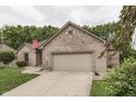 Brick home featuring an attached garage, well-maintained lawn, and traditional design elements at 5499 Steven Dr, Greenwood, IN 46142
