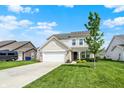 Beautiful two-story home with an attached garage, a lush green lawn, and mature trees in a serene setting at 5518 Wood Spring Ln, McCordsville, IN 46055