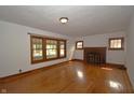 Cozy living room with hardwood floors, a brick fireplace, and natural light from the windows at 6051 Lowell Ave, Indianapolis, IN 46219