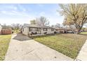 Inviting one-story house showcases a long driveway, and a well-manicured lawn with mature trees at 617 Grovewood Dr, Beech Grove, IN 46107