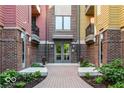 Inviting condo entrance with brick walkway and landscaped flowerbeds leading to a secure glass-door entry at 622 E 10Th St # 212, Indianapolis, IN 46202