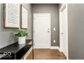 Modern condo entryway featuring hardwood floors, stylish décor, and white trim at 622 E 10Th St # 212, Indianapolis, IN 46202