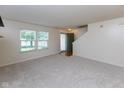 Bright living room with neutral carpet, a large window, and staircase access at 6516 Amherst Way, Zionsville, IN 46077