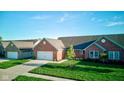 View of a well-maintained brick home with a two-car garage and green lawn at 710 Monarch Ln, Lebanon, IN 46052