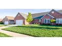 Charming brick home featuring an attached two-car garage and a well-manicured lawn at 710 Monarch Ln, Lebanon, IN 46052