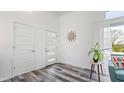 Bright foyer featuring modern doors, wood-look floors, a statement clock, and an inviting plant at 7310 W 100 N, Greenfield, IN 46140