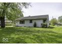 Quaint one story house with clean white siding and verdant front lawn at 7702 Mary Ln, Indianapolis, IN 46217