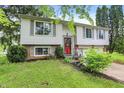 Charming home featuring light siding, a red front door, and a well-manicured front yard at 831 Wakulla Ct, Indianapolis, IN 46217