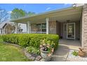 Inviting front porch with beautiful flowers, manicured shrubs, and a welcoming entrance at 8451 Sunningdale Blvd, Indianapolis, IN 46234