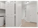 Hallway with laundry closet and view into other rooms showing light-colored floors and doors at 8720 Yardley Ct # 100, Indianapolis, IN 46268