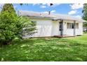 Quaint single-story home with white siding, a covered porch and lush green lawn surrounded by mature landscaping at 1020 E Sixth St, Greenfield, IN 46140